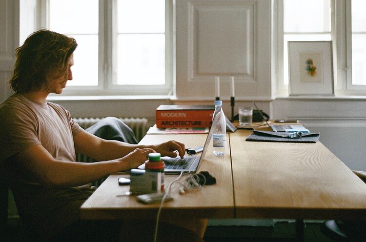 Man with shoulder length hair working remotely 