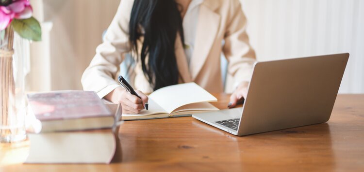 Event planner using laptop and a notebook 