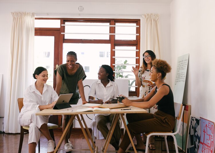 Stock image of women sitting around a table working 