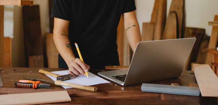 Man with tattoos working at a laptop