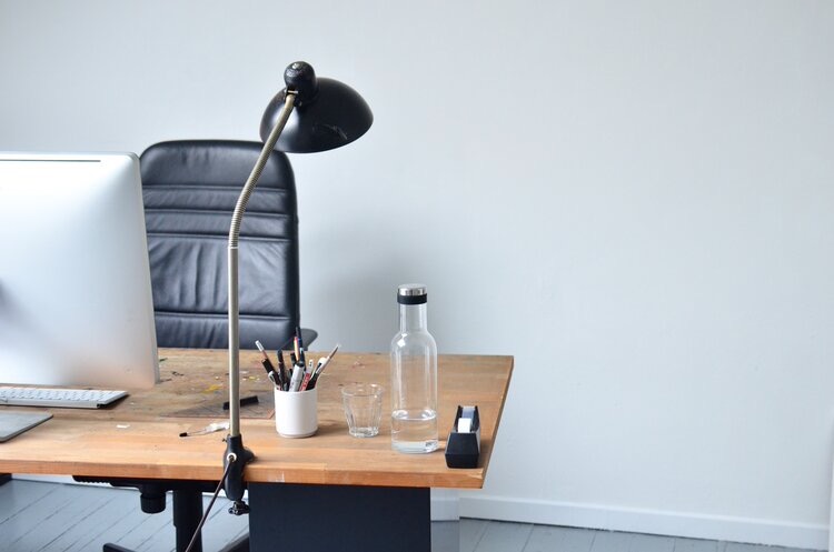 Empty office chair at wood-topped desk