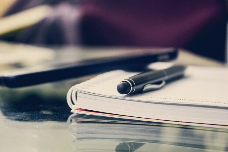 Close up of a pen resting on a notebook