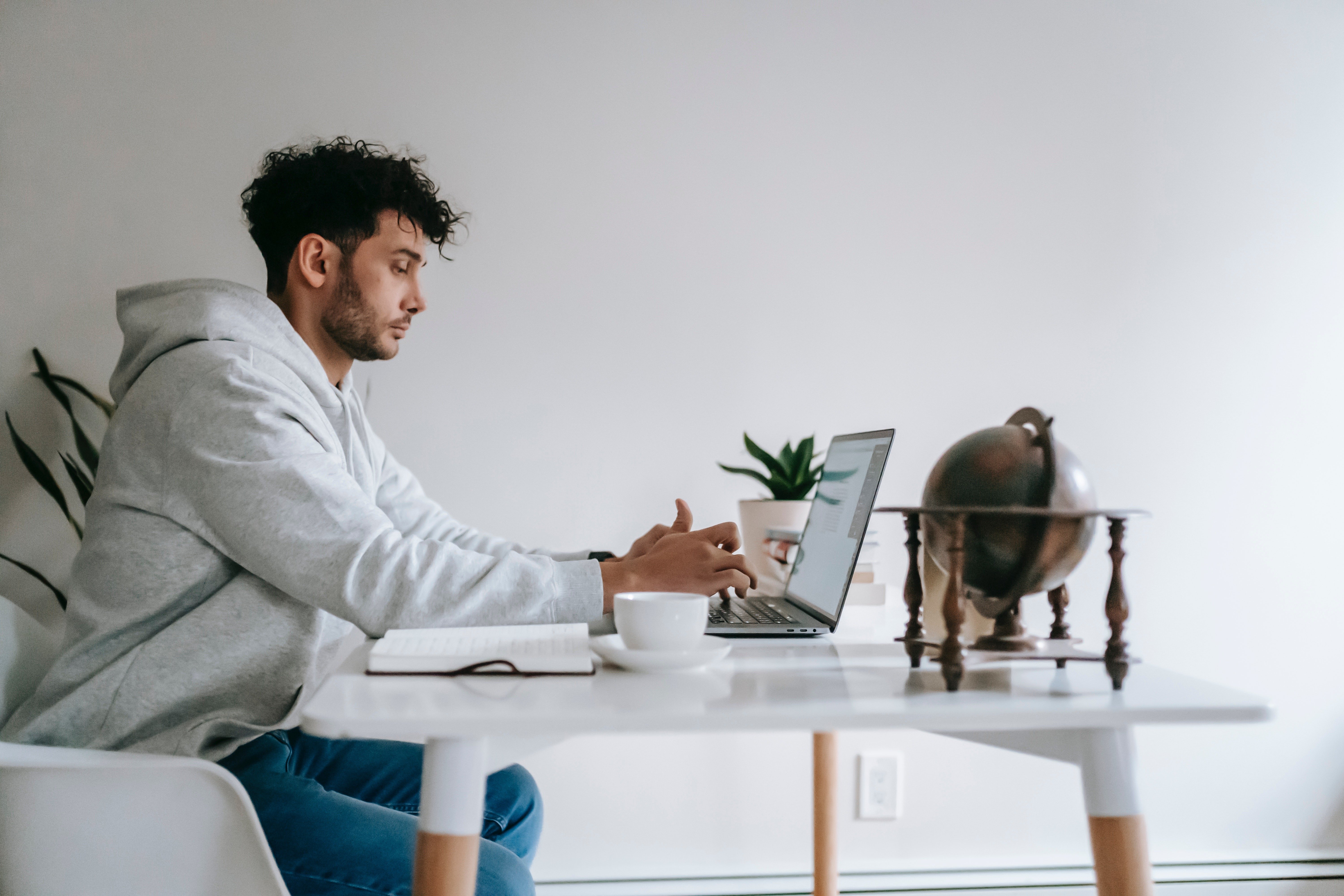 Man in gray sweater working at a computer